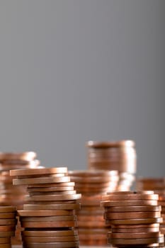 Close up of piles of coins on table, isolated on grey background. business technology, communication and growth concept.