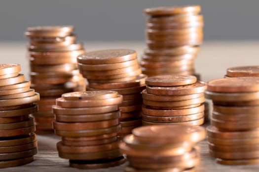 Close up of piles of coins on table, isolated on grey background. business technology, communication and growth concept.