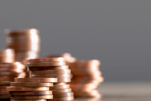 Close up of piles of coins on table, isolated on grey background. business technology, communication and growth concept.