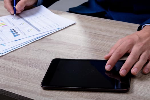 Midsection of caucasian businessman using tablet and taking notes, isolated on grey background. business technology, communication and growth concept.