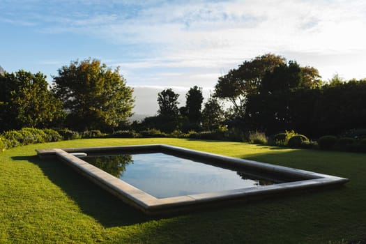 General view of tranquil swimming pool in stunning sunny countryside. outdoor retreat and holiday concept.