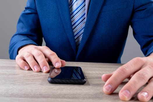 Midsection of caucasian businessman using smartphone, isolated on grey background. business technology, communication and growth concept digitally generated composite image.