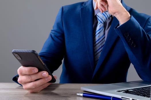 Midsection of caucasian businessman using smartphone, isolated on grey background. business technology, communication and growth concept digitally generated composite image.