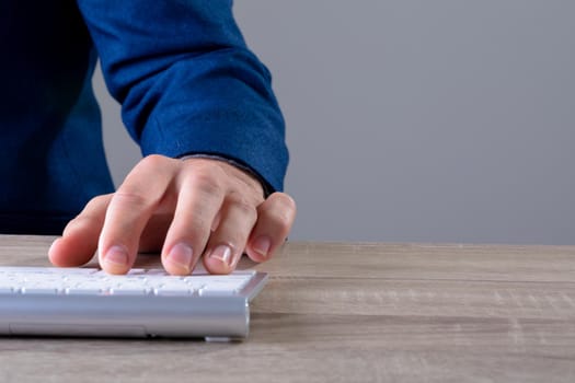 Close up of caucasian businessman typing on keyboard, isolated on grey background. business technology, communication and growth concept digitally generated composite image.