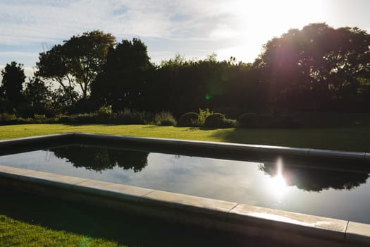 General view of tranquil swimming pool in stunning sunny countryside. outdoor retreat and holiday concept.