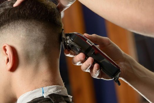 Close up of hair clipper. Person getting a haircut.