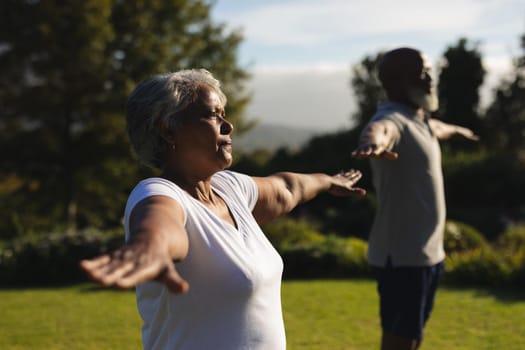 Senior african american couple practicing yoga in stunning countryside. retirement and active senior lifestyle concept.