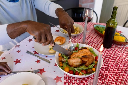 Hands of african american senior man eating christms meal at home. retirement lifestyle and christmas festivities, celebrating at home.