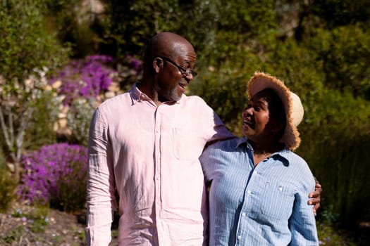Happy african american senior couple embracing outdoors. retirement lifestyle, spending time at home and garden.