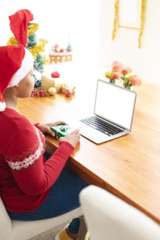 Happy african american plus size woman making christmas video call on laptop with copy space. christmas, festivity and communication technology.