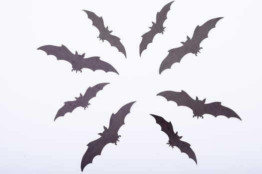 Composition of multiple halloween black bats flying on white background. halloween tradition and celebration concept.