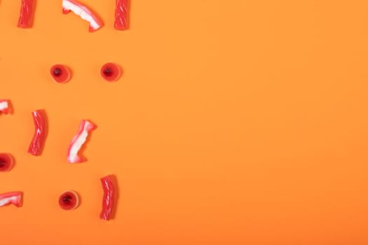 Composition of multiple halloween trick or treat sweets with copy space on orange background. halloween tradition and celebration concept.