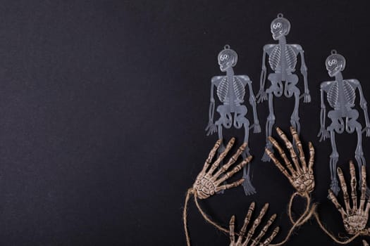 Composition of halloween decorations with skeletons and hands on black background. halloween tradition and celebration concept.