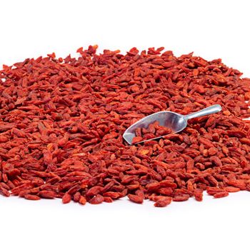 Studio shot of a pile of goji berries with a metal scoop.