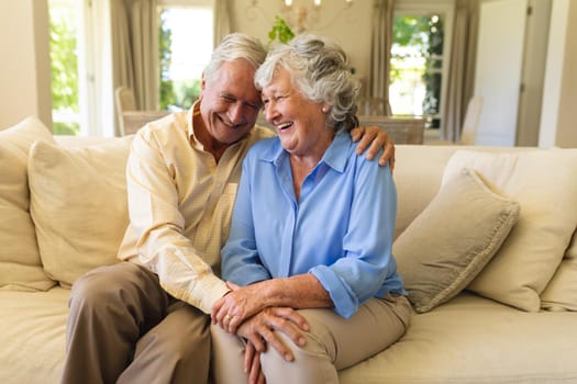Senior caucasian couple sitting on sofa holding hands. retreat, retirement and happy senior lifestyle concept.