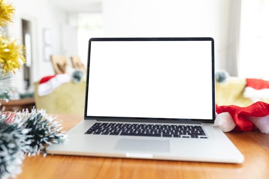 Laptop with copy space on screen lying on table with christmas decorations. christmas, festivity and communication technology.