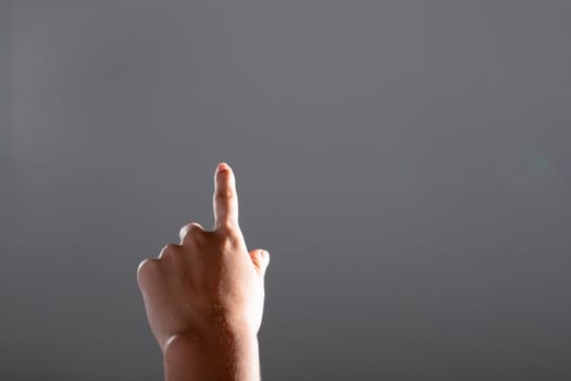 Close up of caucasian businesswoman pointing with her finger, isolated on grey background. business, technology, communication and growth concept.