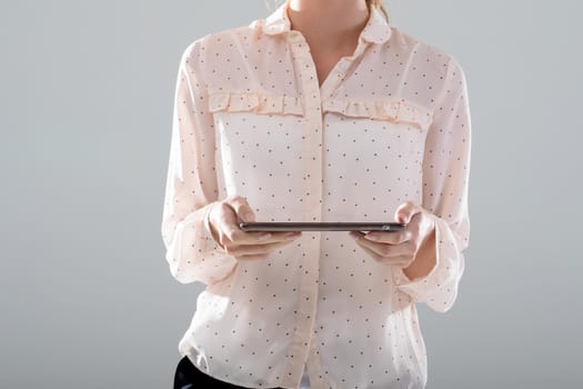 Midsection of caucasian businesswoman using tablet, isolated on grey background. business, technology, communication and growth concept.