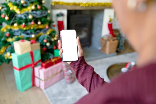 Caucasian woman using smartphone with copy space at christmas time. christmas, festivity and communication technology.