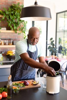 Serious african american senior man cooking in kitchen. retirement lifestyle, leisure and spending time at home.