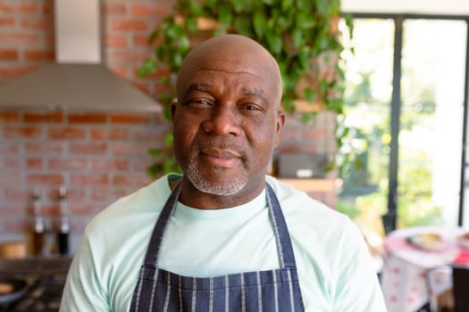 Portrait of serious african american senior man in kitchen. retirement lifestyle, leisure and spending time at home.