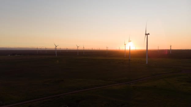 General view of wind turbines in countryside landscape during sunset. environment, sustainability, ecology, renewable energy, global warming and climate change awareness.