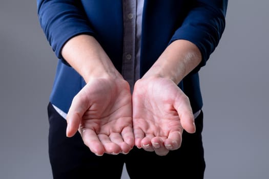 Midsection of caucasian businesswoman showing her hands, isolated on grey background. business technology, communication and growth concept digitally generated composite image.