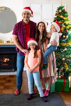 Happy caucasian family wearing santa hat, looking at camera at christmas time. family christmas time and festivity together at home.