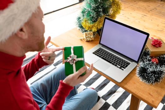 Albino african american man wearing santa hat making video call on laptop with copy space. christmas, festivity and communication technology festivity and communication technology.