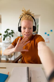 Albino african american man working from home making video call. remote working using technology at home.