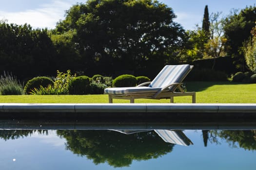 General view of tranquil swimming pool and deckchair with stunning mountains countryside. outdoor retreat and holiday concept.