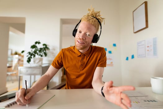 Albino african american man working from home making video call. remote working using technology at home.