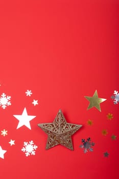 Composition of christmas decorations with stars, snowflakes and copy space on red background. christmas, tradition and celebration concept.