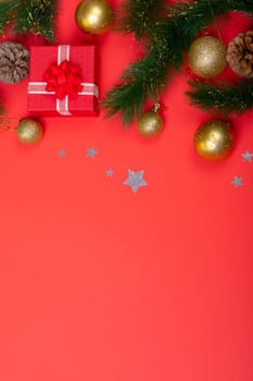 Composition of garland with baubles, presents, pine cones and copy space on red background. christmas, tradition and celebration concept.