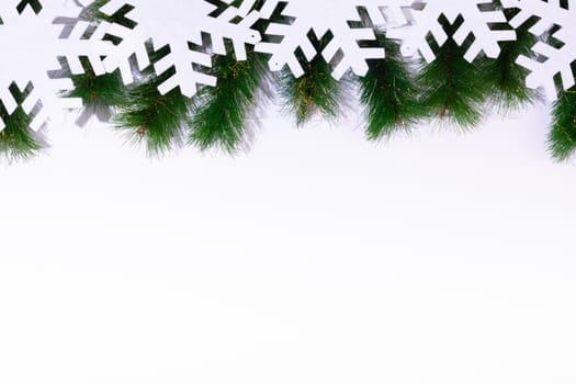 Composition of fir tree branches with snowflakes and copy space on white background. christmas, tradition and celebration concept.
