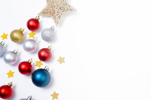 Composition of baubles with stars in shape of christmas tree and copy space on white background. christmas, tradition and celebration concept.