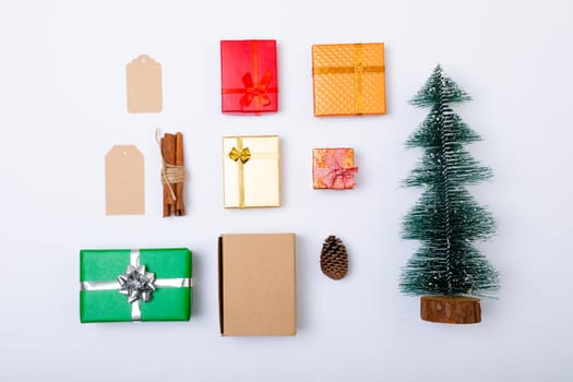 Composition of christmas decorations with presents and christmas tree on white background. christmas, tradition and celebration concept.