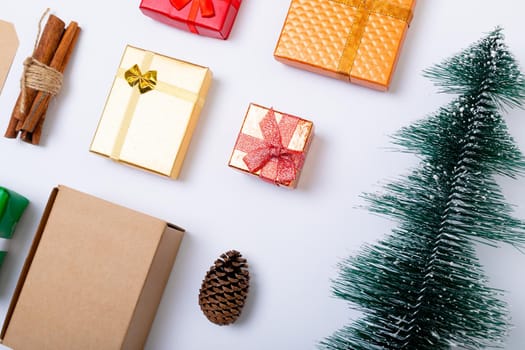 Composition of christmas decorations with presents and christmas tree on white background. christmas, tradition and celebration concept.