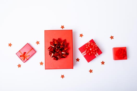 Composition of red christmas presents and stars on white background. christmas, tradition and celebration concept.