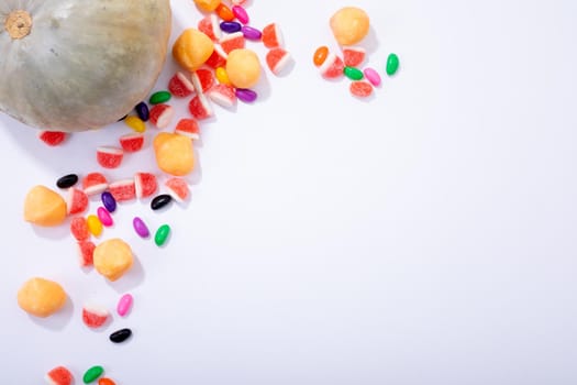 Composition of halloween pumpkin and trick or treat sweets with copy space on white background. halloween tradition and celebration concept.