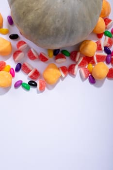 Composition of halloween pumpkin and trick or treat sweets with copy space on white background. halloween tradition and celebration concept.