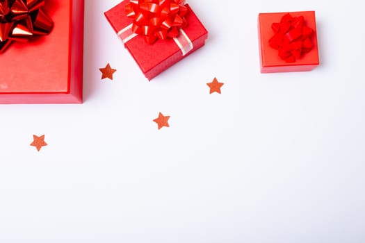 Composition of red christmas presents and stars with copy space on white background. christmas, tradition and celebration concept.