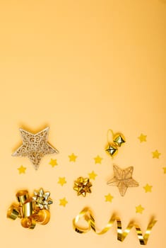 Composition of christmas decorations with ribbons, stars and copy space on yellow background. christmas, tradition and celebration concept.