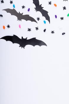 Composition of halloween decorations with spiders, bats and sweets on white background. halloween tradition and celebration concept.