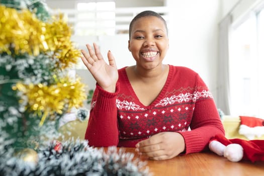 Happy african american plus size woman i making christmas video call on laptop. christmas, festivity and communication technology.