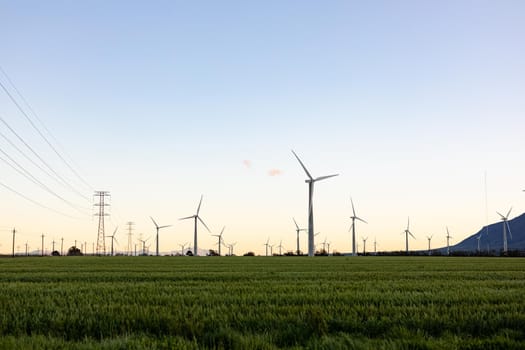 General view of wind turbines in countryside landscape with cloudless sky. environment, sustainability, ecology, renewable energy, global warming and climate change awareness.
