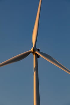 Close up of wind turbine in countryside landscape with cloudless sky. environment, sustainability, ecology, renewable energy, global warming and climate change awareness.