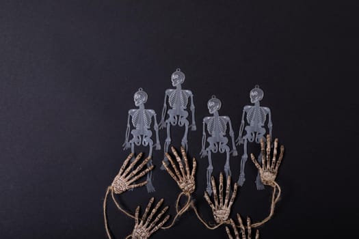 Composition of halloween decorations with skeletons and hands on black background. halloween tradition and celebration concept.