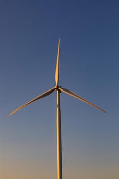 Close up of wind turbine in countryside landscape with cloudless sky. environment, sustainability, ecology, renewable energy, global warming and climate change awareness.