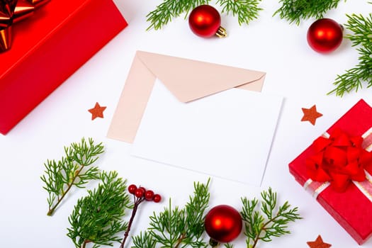 Composition of envelopes with copy space and christmas decorations with presents on white background. christmas, tradition and celebration concept.